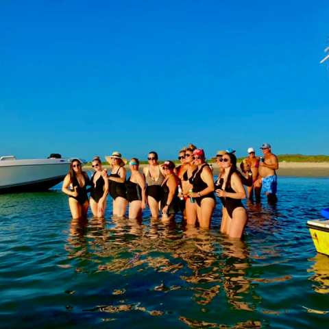 a group of people standing next to a body of water